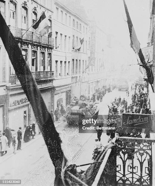 Allied army tanks rumble through the streets of Liege, Belgium as the residents cheer after the liberation of Belgium from German occupying forces...