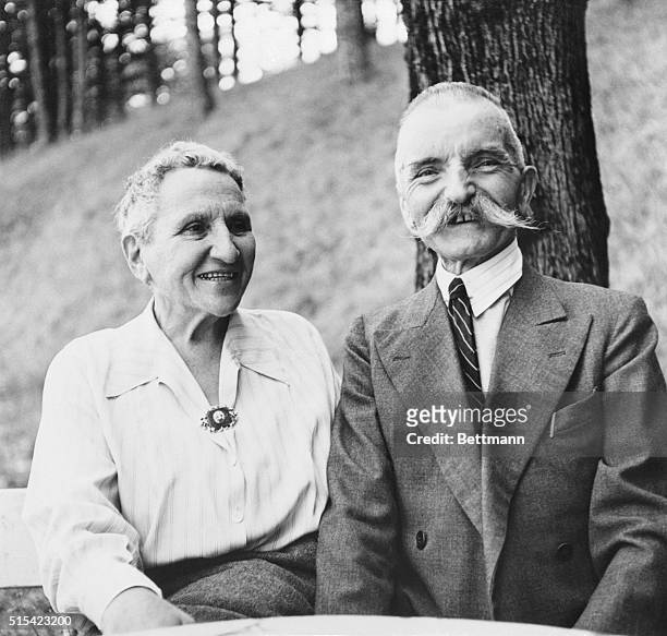 Gertrude Stein in France with French Mayor Justin Rey. France: At a table beneath a tree, Miss Gertrude Stein, noted novelist, smiles and chats with...