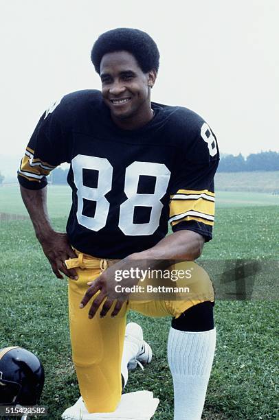 Pittsburgh Steelers' wide receiver Lynn Swann bends down on one knee and smiles.