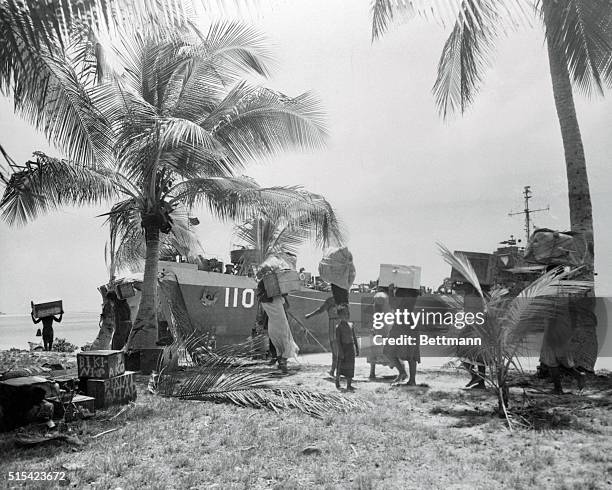 Natives of Bikini Atoll in the Pacific, scene of the planned Army-Navy atom bomb test scheduled for May carry their belongings down to the beach as...