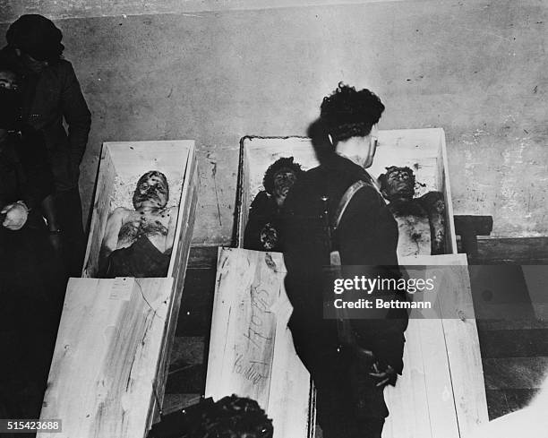 An Italian partisan stands over the bodies of Italian Fascist dictator Benito Mussolini, his 33-year-old mistress Claretta Petacci, and Fascist party...