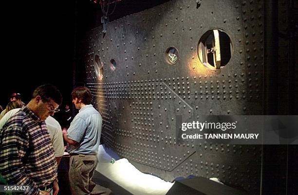 Visitors look at a 13 ton section of the hull of the Titanic on display at the Titanic exhibit 18 February 2000 at the Museum of Science and Industry...