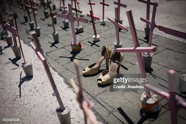 High heel shoes are seen in front of a cross outside the Municipal Palace of Ecatepec during a protest against femicides in Ecatepec, Mexico on March...