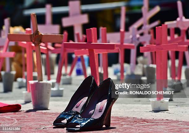 High-heeled shoes from a victim of femicide are pictured next to crosses during a protest against the murder of more than 600 women in the last four...