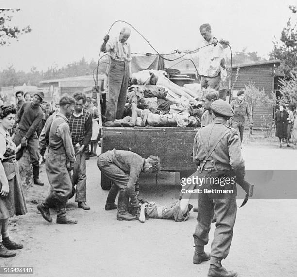 German SS men, captured when British 2nd Army forces invaded the Nazi concentration camp at Belsen, are made to load the bodies of the starved and...