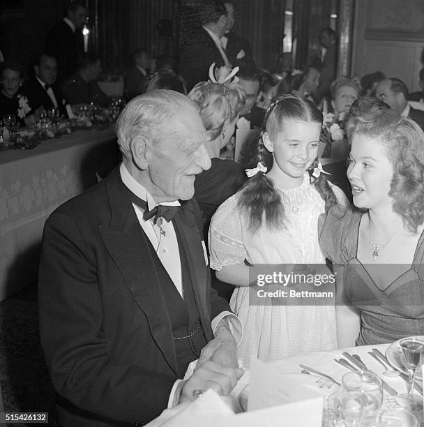 Veteran screen actor C. Aubrey Smith chats with child star Margaret O'Brien and Shirley Temple at Beverly Hills Hotel where they attended function...