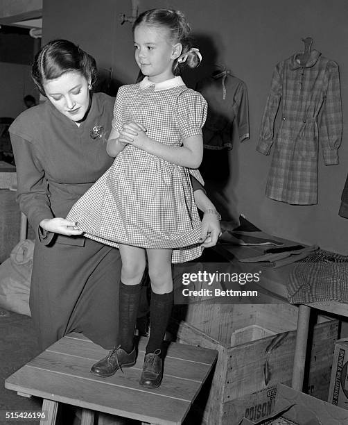 Models Dresses to be Sent to Russian Orphans. New York: Natalie Wood, six-year-old actress, poses in the first dress made inthis country from a...