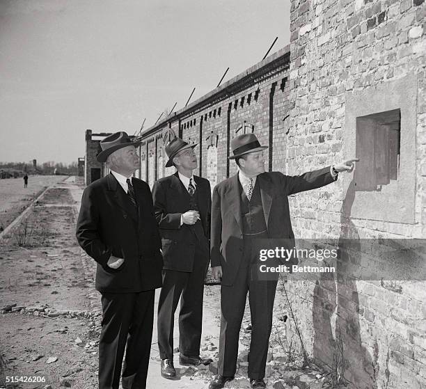 Herbert Hoover looks at a well protected gun slit in the "Ghetto Wall" of Warsaw. From the safety of the slits, Nazis would blast at defenseless Jews...
