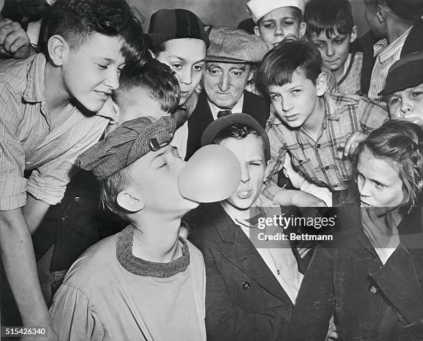 Robert Moses shows an envious throng the technique which won him first prize in a bubble gum blowing contest sponsored by a Chicago candy store....