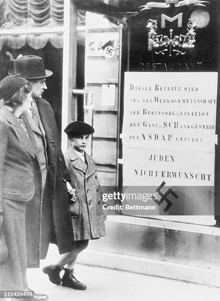 Germany lost little time following its annexation of Austria to Nazify that land. Here is a typical Vienna street scene with a notice posted on the...