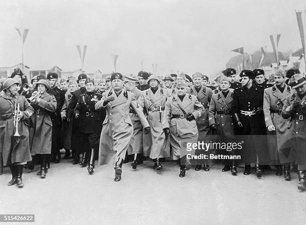 Setting an example for his admiring staff, Premiere Benito Mussolini of Italy is shown here doing the goose step, Germany's ceremonial military...