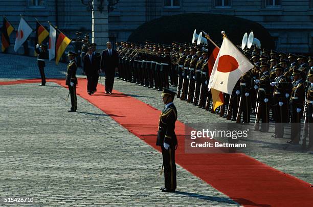 Tokyo, Japan: West German chancellor Helmut Kohl and his Japanese counterpart, Yasuhiro Nakasone, review the guard of honor during a welcoming...