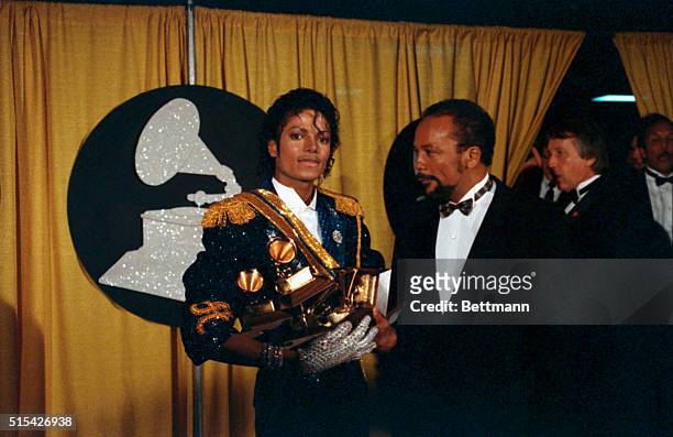 Singer Michael Jackson is shown with two armfuls of award statues at the 1984 Grammy Awards.