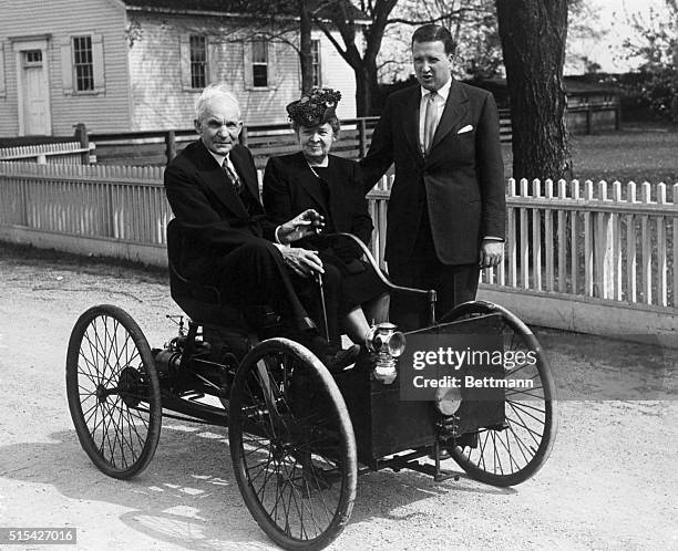 Dearborn, MI- Shown here is the late Henry Ford seated in the first car he built in 1896. With him is the late Mrs. Ford and standing is Henry Ford...