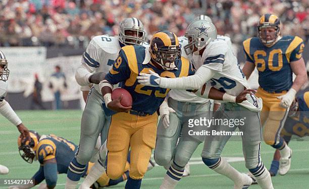 Irving, Tex.: Los Angeles running back Eric Dickerson, is tackled by Dallas Cowboys, Michael Downs, , after running for 19-yards and a first down in...