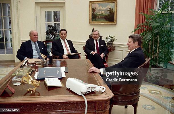 Washington, DC- Reagan meets with Secretary of State George Schultz, in the Oval Office 2/19, to discuss Schultz's trip for a series of pre-summit...