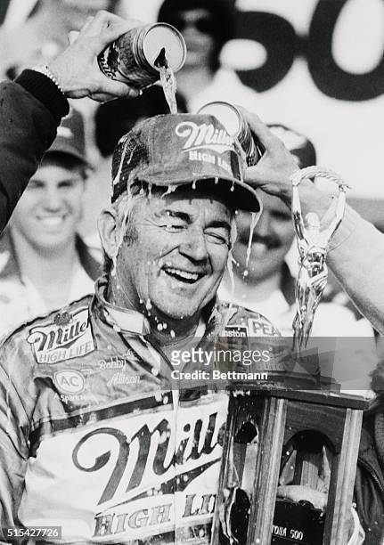 Daytona Beach, Florida: Bobby Allison of Hueytown, Alabama, is covered with beer 2/14, in winner's circle after driving his Buick to win the Daytona...