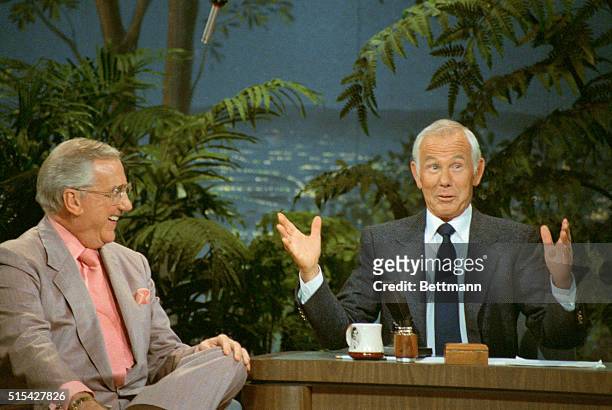 Talk show host Johnny Carson gestures while talking to co-host Ed McMahon on The Tonight Show.