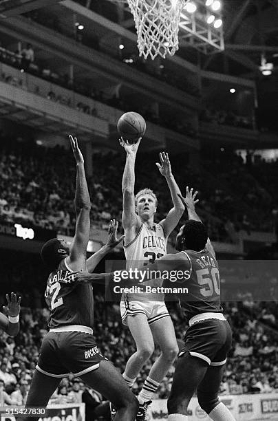 Larry Bird shoots over Rockets' Joe Barry Carroll and Robert Reid during first quarter action at Boston Garden, 3/30.