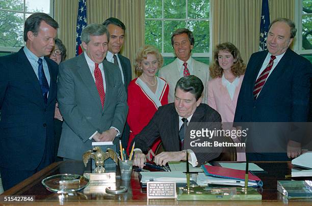 Members of the National day Prayer organizing committee looking on, including entertainer Pat Boone, , President Reagan signs a proclamation honoring...