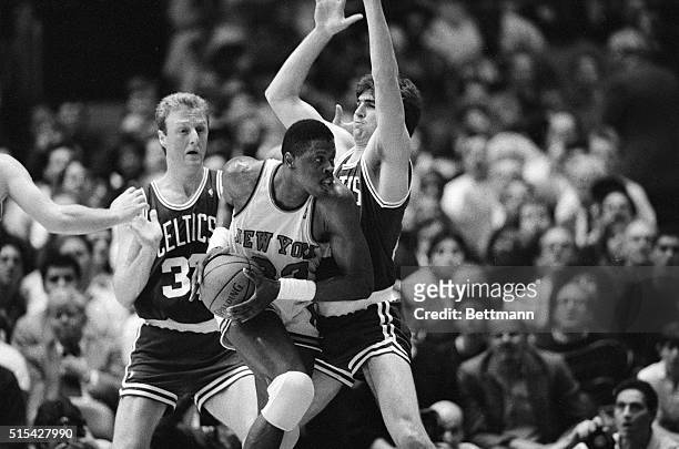 New York Knicks' Patrick Ewing makes a move to the basket on the Boston Celtics' Larry Bird and Mark Acres during the first half of their Eastern...