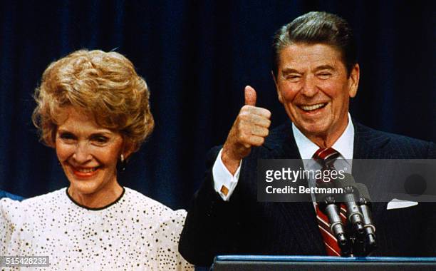 Los Angeles, California: President Reagan gives victory thumbs up sign as First Lady Nancy smiles to crowd at Century Plaza Victory 84 Celebration.