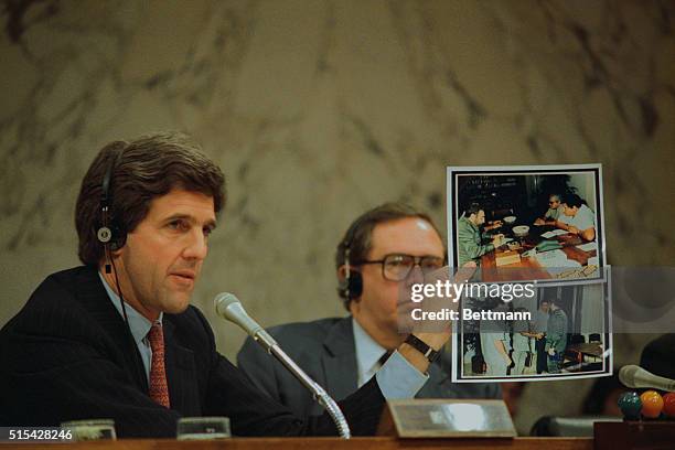 Senator John Kerry, chairman of the Senate Foreign Relations subcommittee, displays photos showing Cuban leader Fidel Castro meeting with Panamanian...