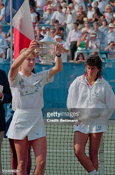 New York: A dejected Gabriela Sabatini looks at Steffi Graf as she holds up the U.S. Open Cup after completing the Grand Slam by winning the...