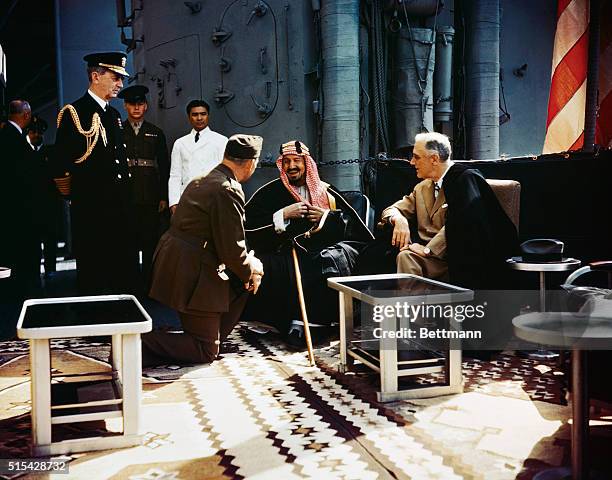 King Abdul Aziz bin Abdul Rahman Al Saud of Saudi Arabia in conference with President Franklin Delano Roosevelt aboard the USS Quincy at the Great...