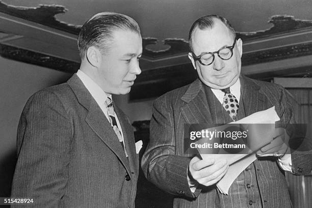Lee MacPhail , general manager of Kansas City Blues, and George Weiss, general manager of New York Yankees, look over player list at start of the...