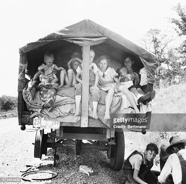Truckload of Dust Bowl refugees wait for a flat on their truck to be fixed. | Location: Weber Falls, Oklahoma, USA.