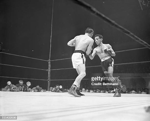 Featherweight champ Willie Pep is shown landing a hard right to French challenger Ray Famechon's midsection during tonight's 15-round title bout at...