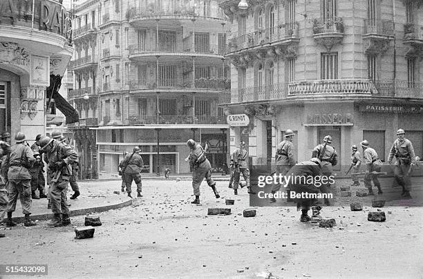 Algiers, Algeria- Riot police here throw tear gas bombs and stones at demonstrators Dec 10 as they try to clear this street in the middle of the city...