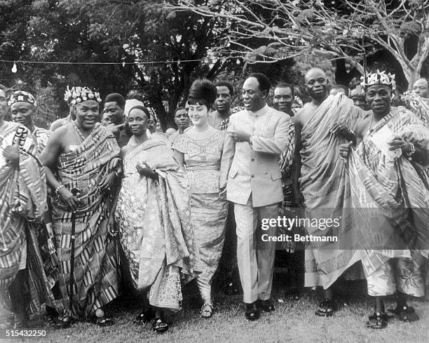 Accra, Ghana- Ghana President Kwame Nkrumah and his Egyptian-born wife, Madame Fathia Nkrumah , are flanked by paramount Chieftains as they dance to...