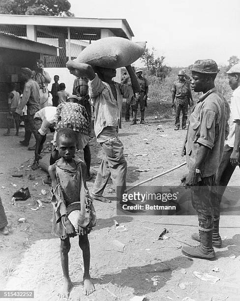 Owerri, Nigeria- Holding his pan, a young refugee waits for food at a distribution center. Nigerian authorities in Port Harcourt held incommunicado...