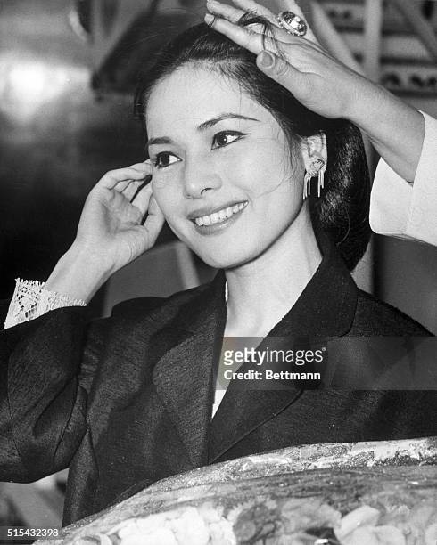 London, England- Having her hair put back in place by the helping hand of a friend, Ratna Sari Dewi Sukarno smiles as she arrives in London. The...