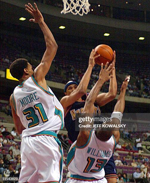 Denver Nuggets' Chris Gatling puts up a shot in front of Detroit Pistons' Mikki Moore and Jerome Williams during the first quarter 08 March 2000 at...