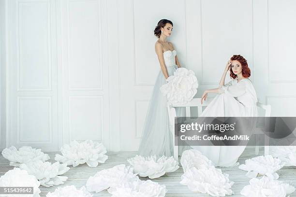 studio shot of two young beautiful brides - white wedding dress stock pictures, royalty-free photos & images