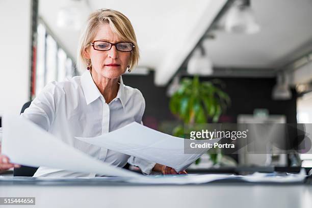 donna d'affari esaminando i documenti sulla scrivania - documento foto e immagini stock