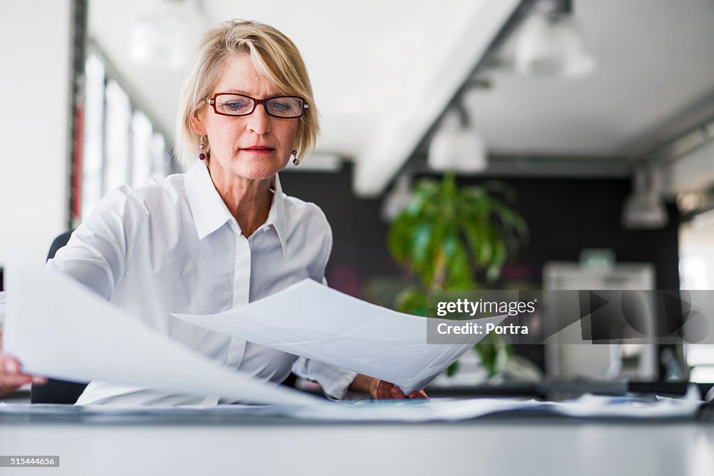 Businesswoman examining documents at desk