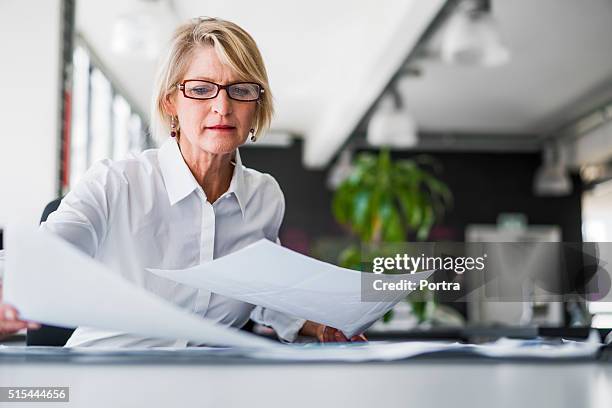 empresária examinar documentos na secretária - documento imagens e fotografias de stock