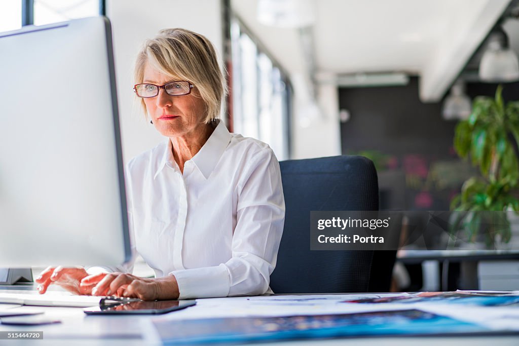 Businesswoman using computer at desk in office