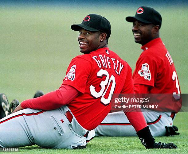 Cincinnati Reds' outfielders Ken Griffey Jr and Michael Tucker share a laugh as they warm up before the start of a spring training game against the...