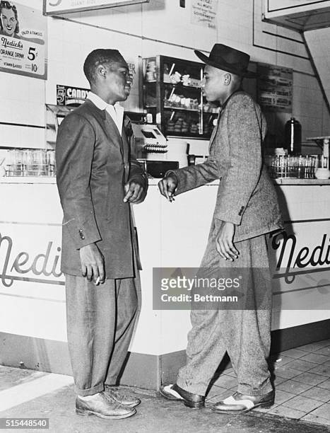 Zoot by any other name, a patriot just the same. Two men stand at a soda fountain wearing zoot suits.