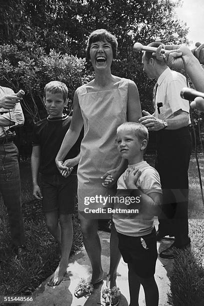 Seabrook, TX- Mrs. Janet Armstrong, accompanied by her two sons, Eric and Mark talk to newsmen in front of her home 7/17. Mrs. Armstrong watched the...