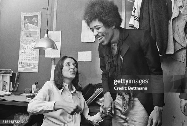 Folk singer Joan Baez and rock singer Jimi Hendrix chat between acts at a Biafran Relief Benefit show at a place in Manhattan called Steve Paul's...
