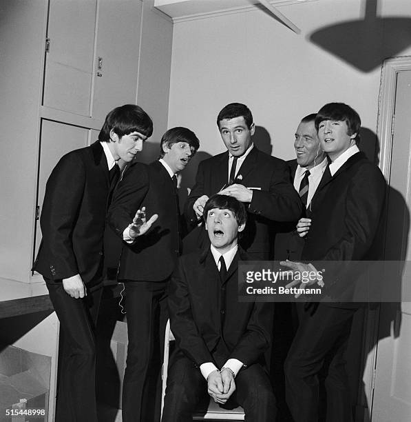 American television host Ed Sullivan poses, with members of British rock group the Beatles and Olympic speed skater Terry McDermott , backstage...