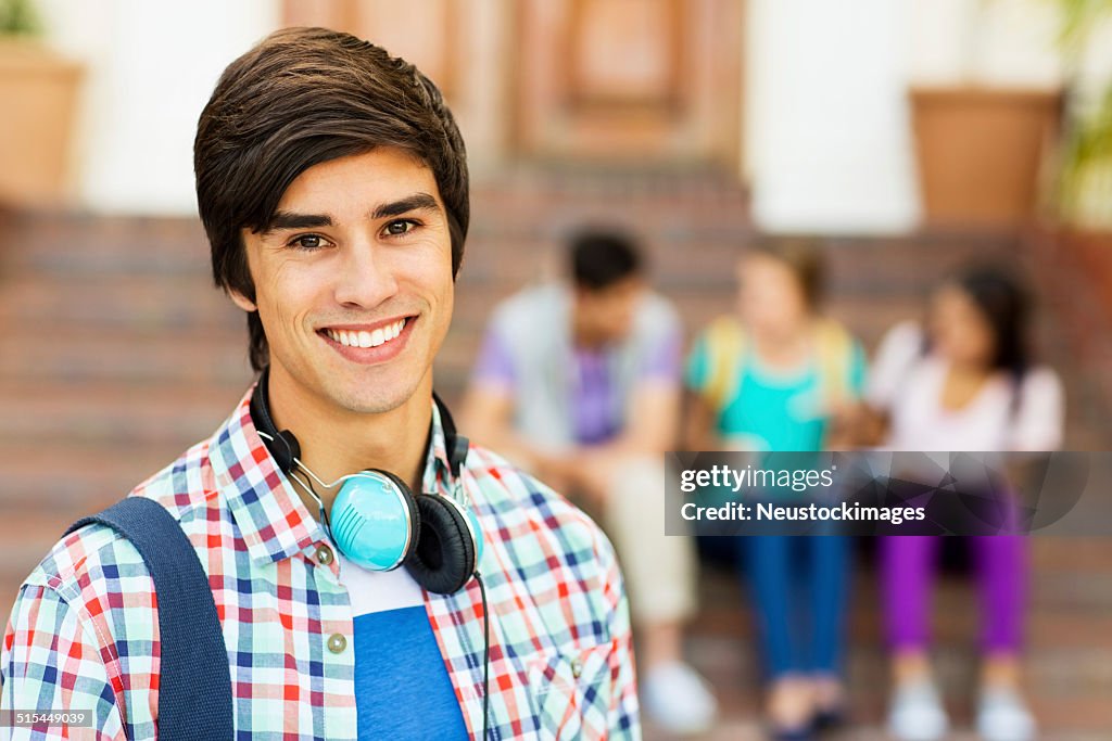 Male Student With Students Sitting In Background On College Camp