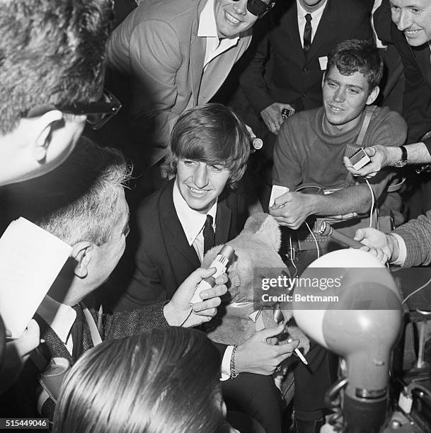 San Francisco, California- Ringo Starr of the Beatles sits holding a stuffed bear as he's surrounded by newsmen upon his arrival at San Francisco...