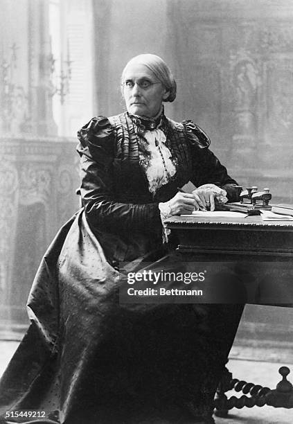 Suffragist Susan B. Anthony , seated at her desk.